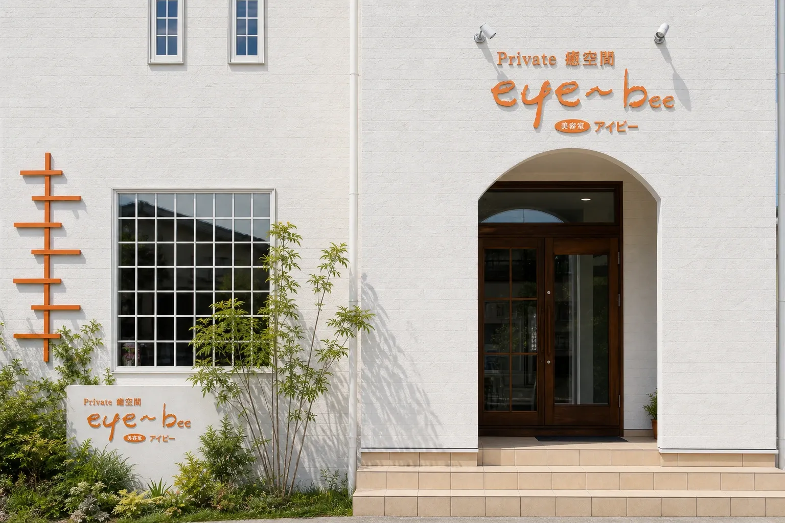 美容室アイビーの白い外観。切妻屋根とアーチ型の木製ドアを正面から見た様子。